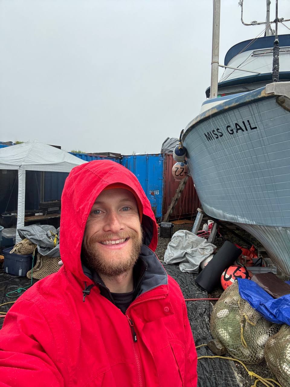 Smiling crew selfie in front of the boat