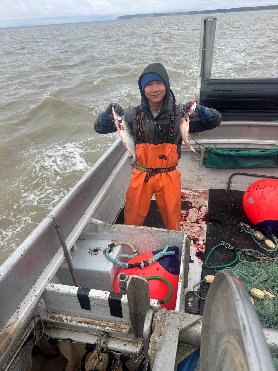 Crew member holding wild salmon on deck
